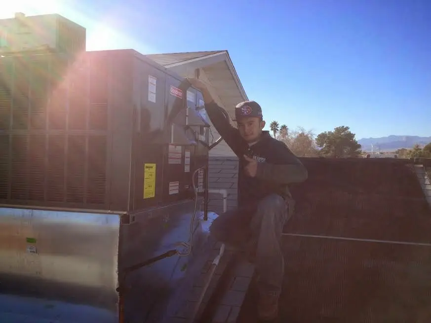 HVAC technician performing HVAC Inspection on a rooftop unit in Cottage Grove